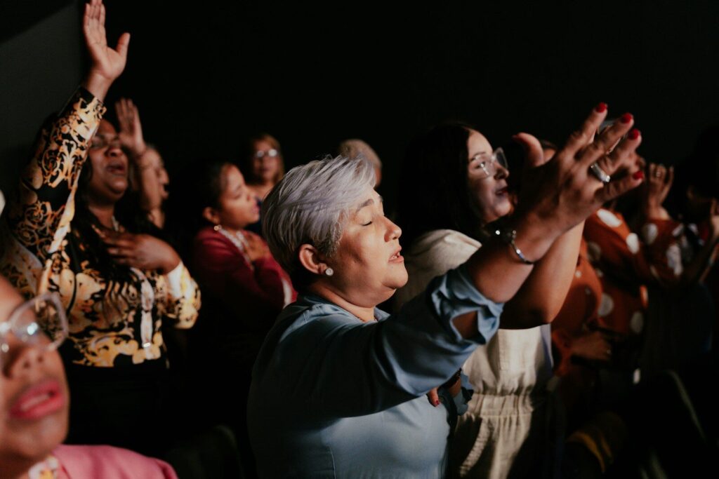 a group of people standing in a room with their hands in the air