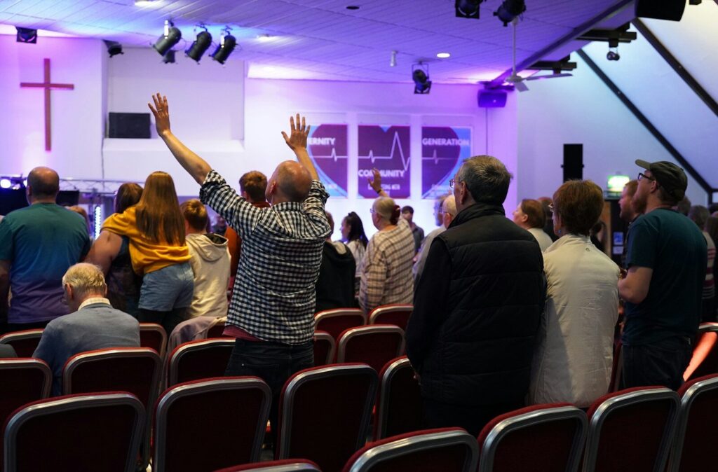a group of people standing in a room with their hands in the air