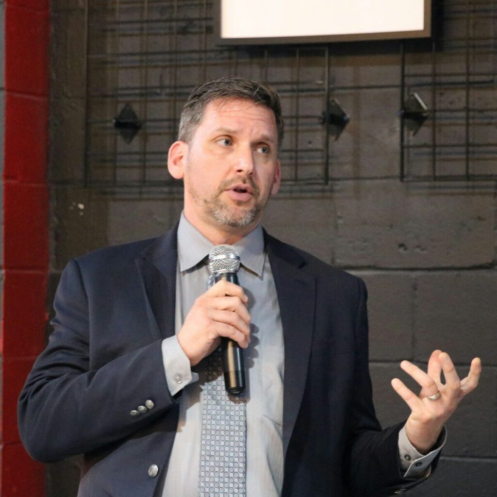 A man in a suit speaking into a microphone
