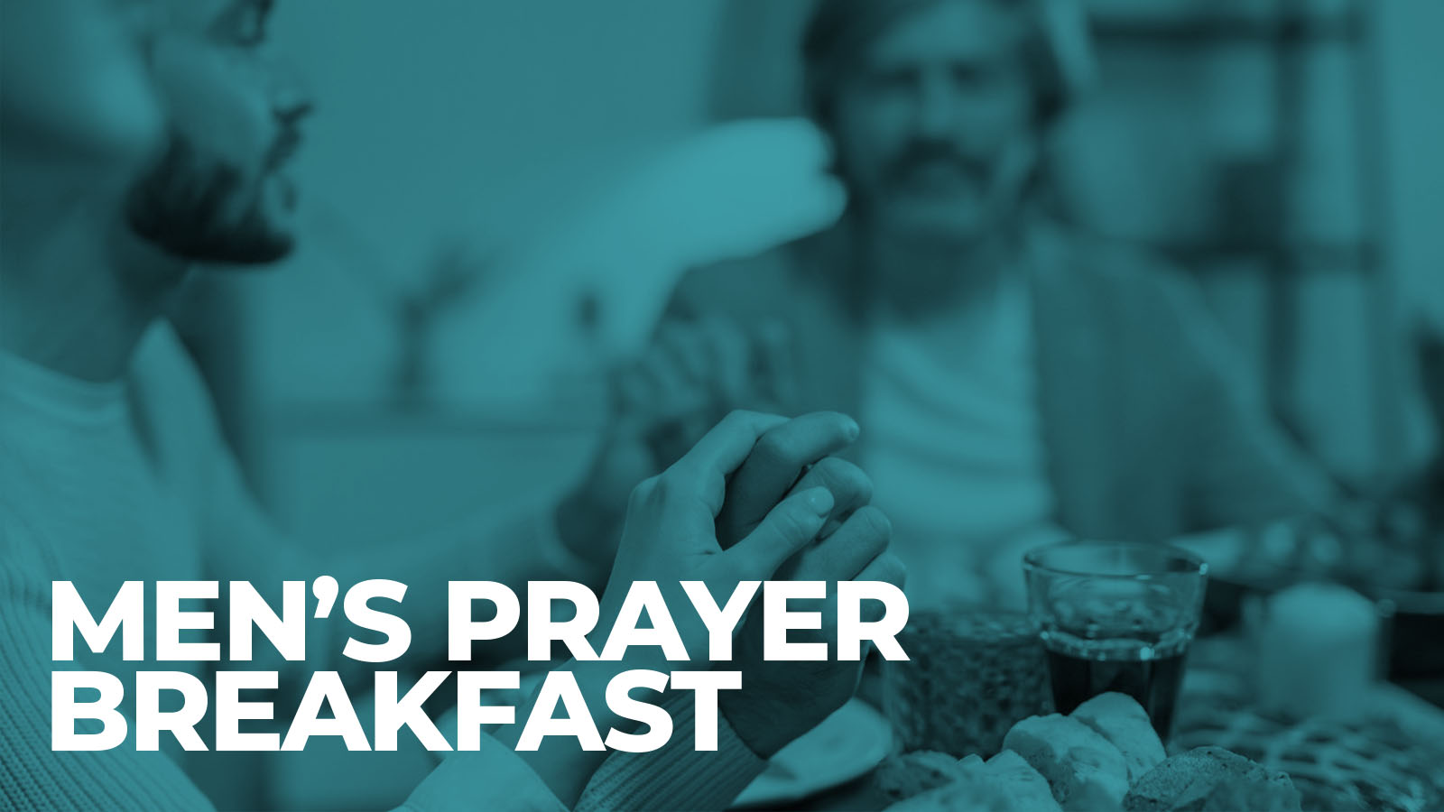 Men praying together over breakfast table